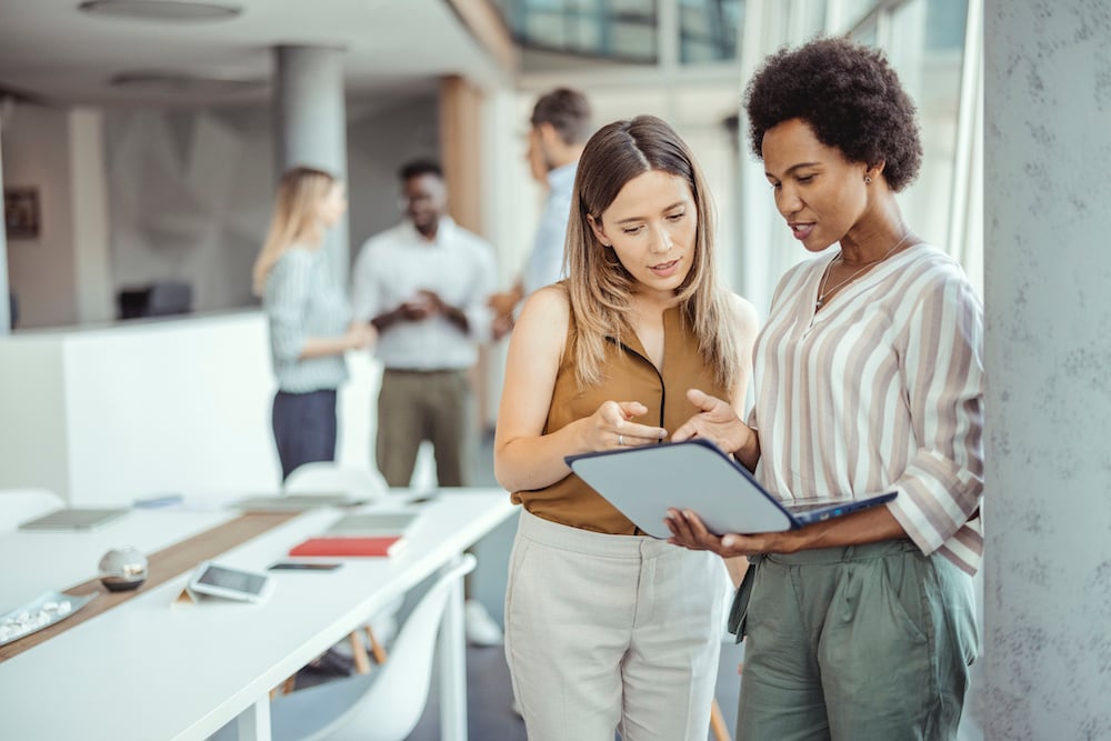 image of two businesswomen reviewing laptop