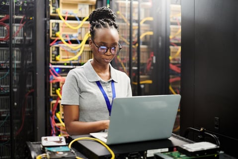 technician on laptop in server room